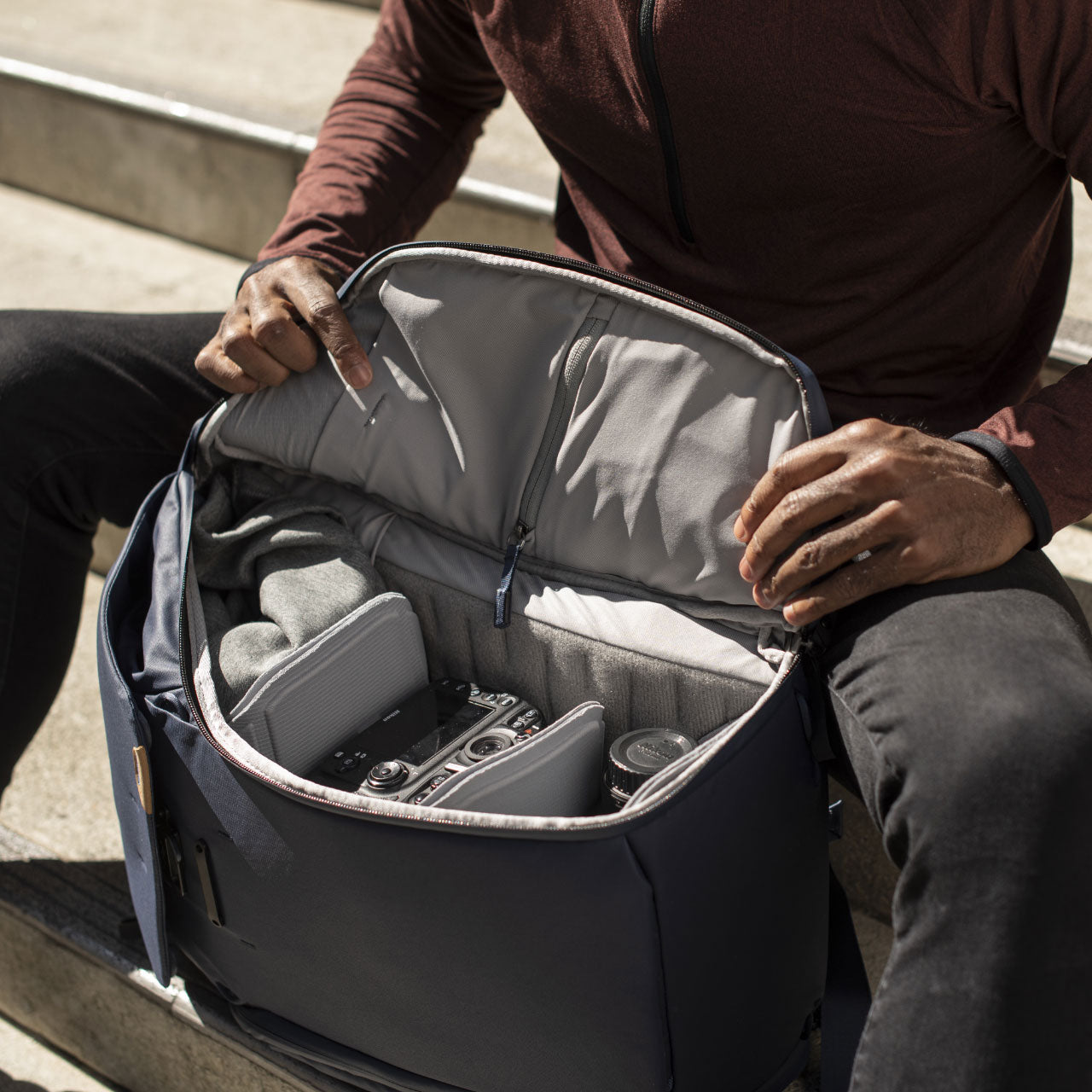 Man opening side zipper of Everyday Backpack