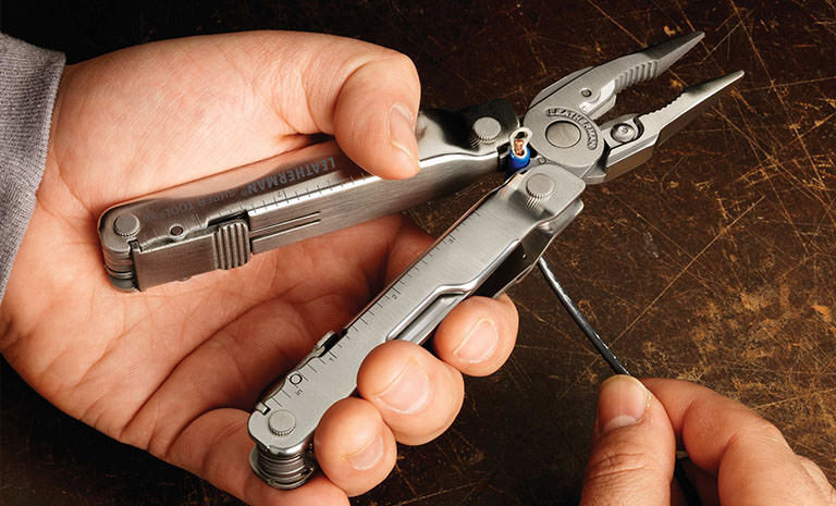 Man using Leatherman Super Tool 300 to strip wire